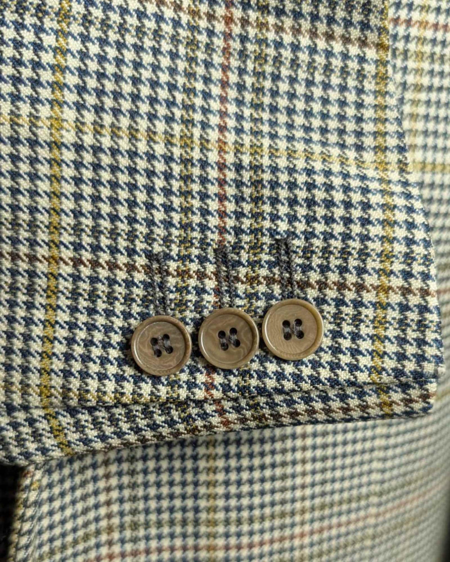 Detailansicht der Knöpfe eines Männer-Sakkos in hellem Karo-Muster Design