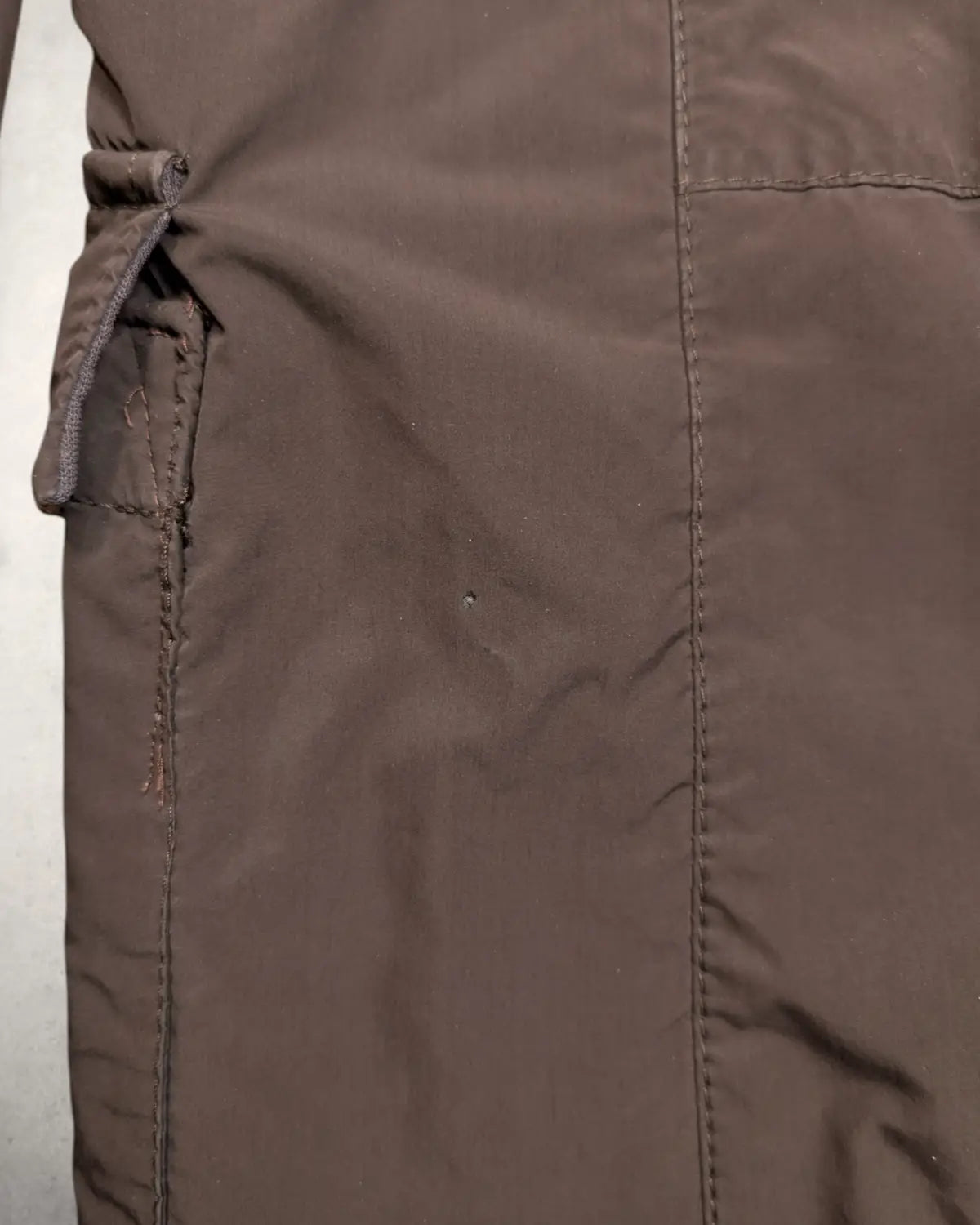 Nahaufnahme der Beschädigung: Kleines Loch hinter der linken Pattentasche der Pal Zileri Jacke.