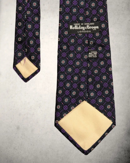 Holliday and Brown Etikett in einer Handmade Seidenkrawatte in floralem Muster.