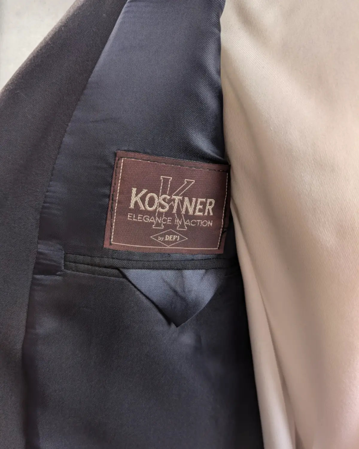 Etikett der Firma Kostner aus Südtirol in einem navyfarbenem Sakko