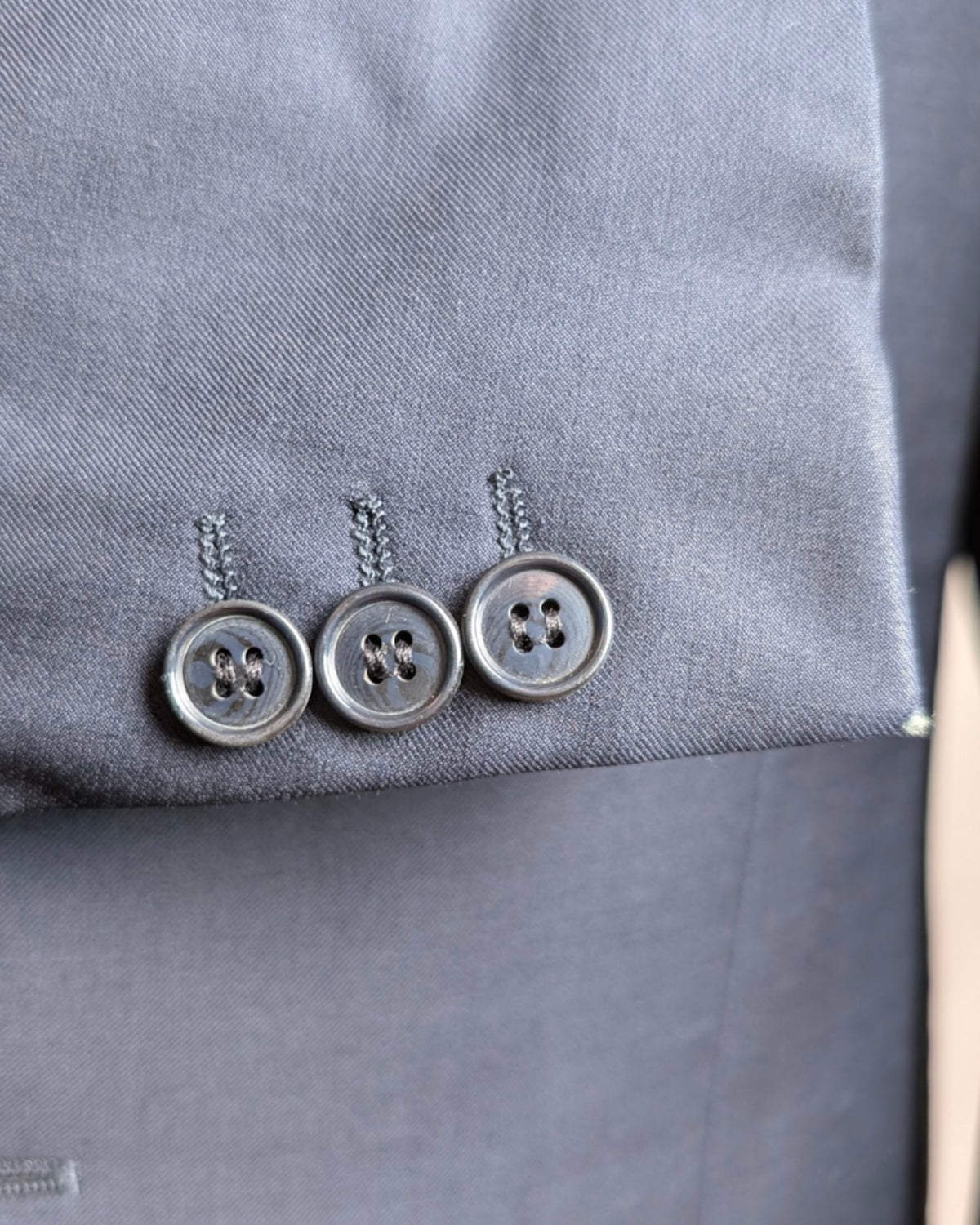 Knopfleiste eines Boglioli Herrensakkos aus Loro Piana Stoff mit kleinem Loch