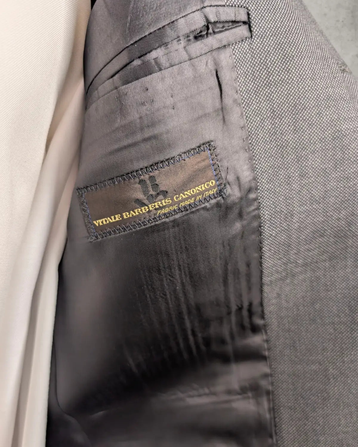 Etikett von Vitale Barberis Canonico in einem grau schwarzem Herrensakko in Größe 48