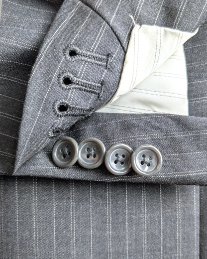 workings cuffs (funktionelle Ärmelknöpfe) eines Sini Collection Anzugs aus anthrazitfarbener Schurwolle mit Nadelstreifen, Größe 48, in der Detailansicht.